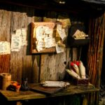Rustyczne zwoje i notatki na stole w scenerii przypominającej Hobbiton