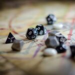 Czarno-białe kości wielościenne rozrzucone na mapie gry RPG