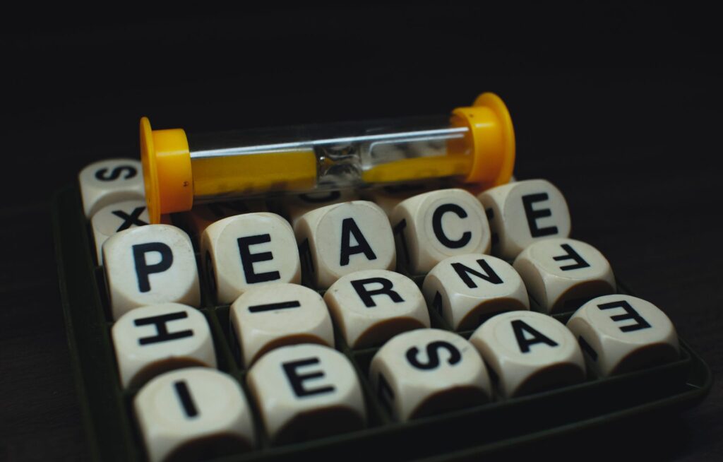 Kości układające napis PEACE obok klepsydry